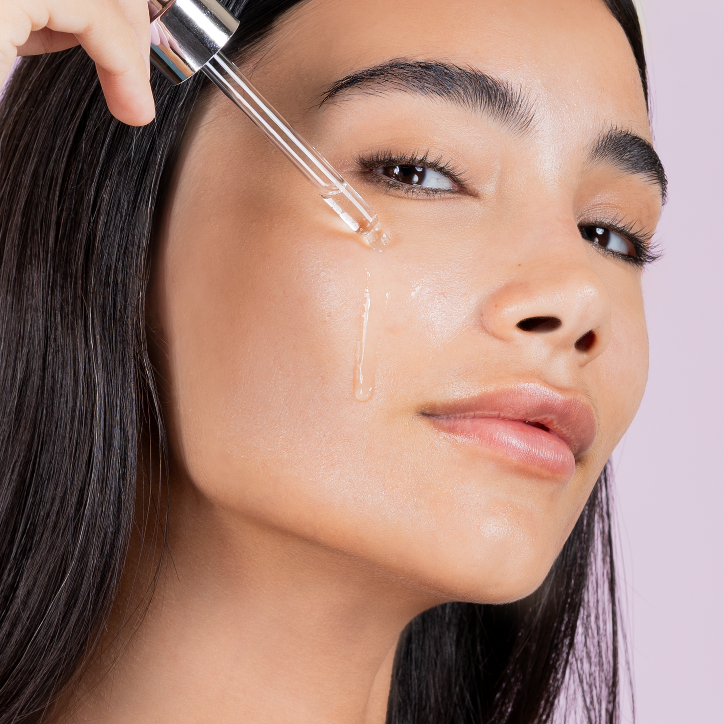 Model applying Mirror Skin Aqualift serum on her face