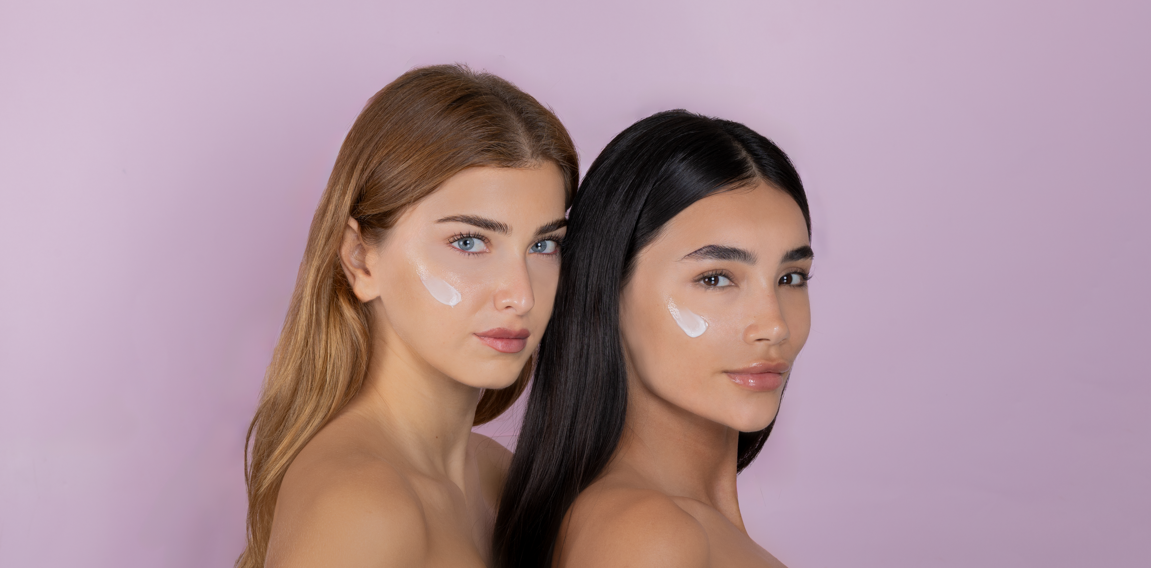 Two women with glowing skin applying clean vegan skincare cream by Mirror Skin