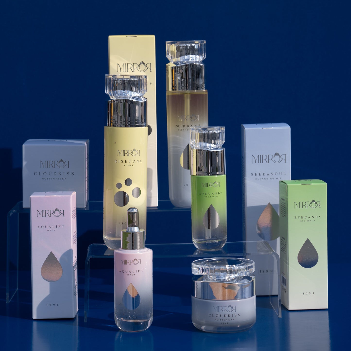 Full Mirror Skin clean skincare collection including Seed & Soul Cleansing Oil, Risetone Toner, Eyecandy Eye Serum, Aqualift Serum, and Cloudkiss Moisturizer displayed on a blue gradient background.