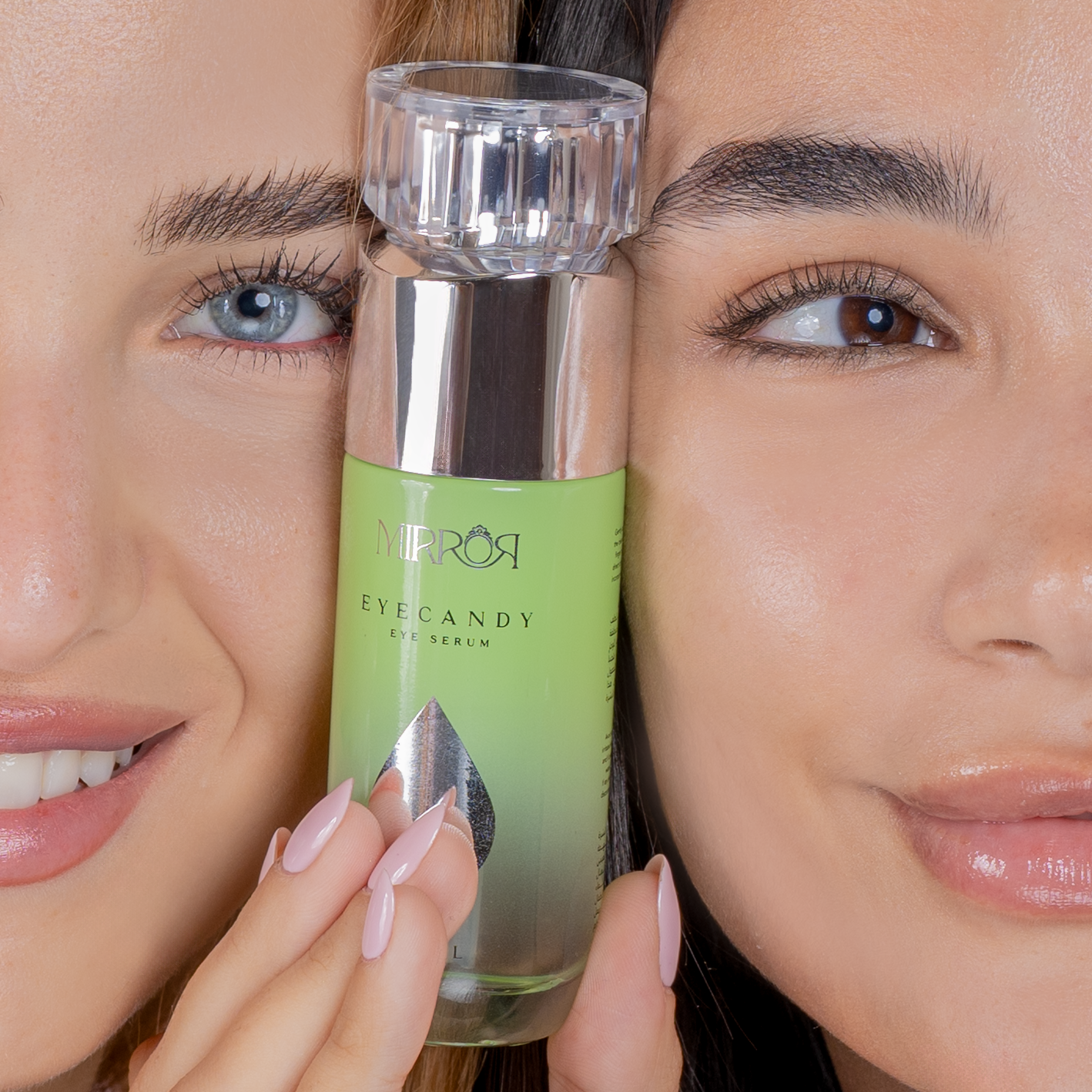 Two women holding a bottle of Mirros Eye Candy Eye Serum between them.