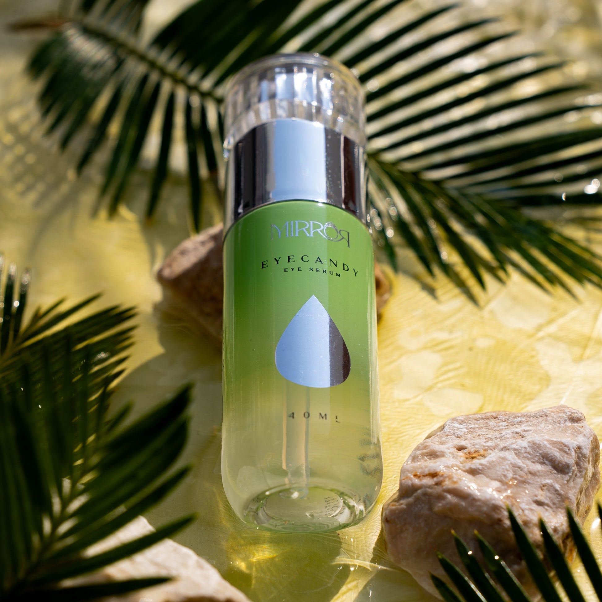 Mirror Skin Eyecandy serum placed among palm leaves