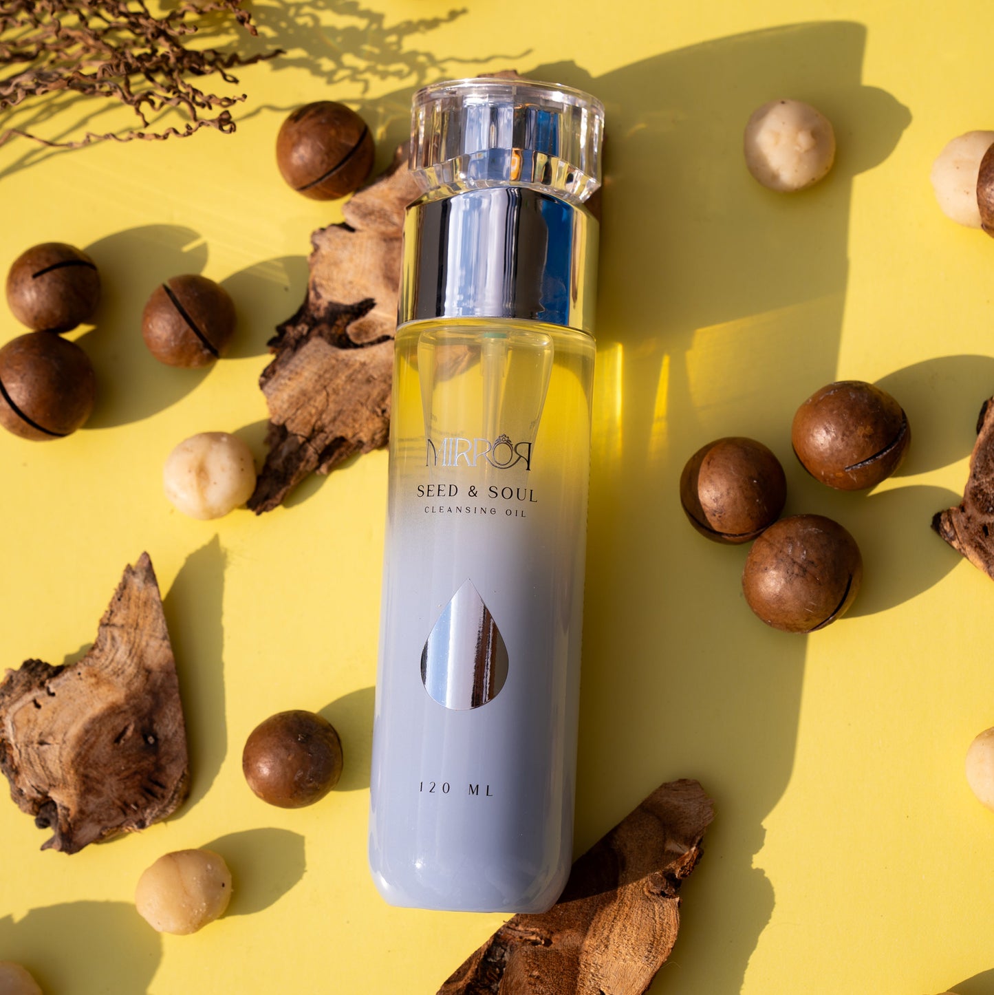 Mirror Skin Seed & Soul Nourishing Cleansing Oil bottle displayed with macadamia nuts and natural oils, highlighting clean vegan skincare ingredients.