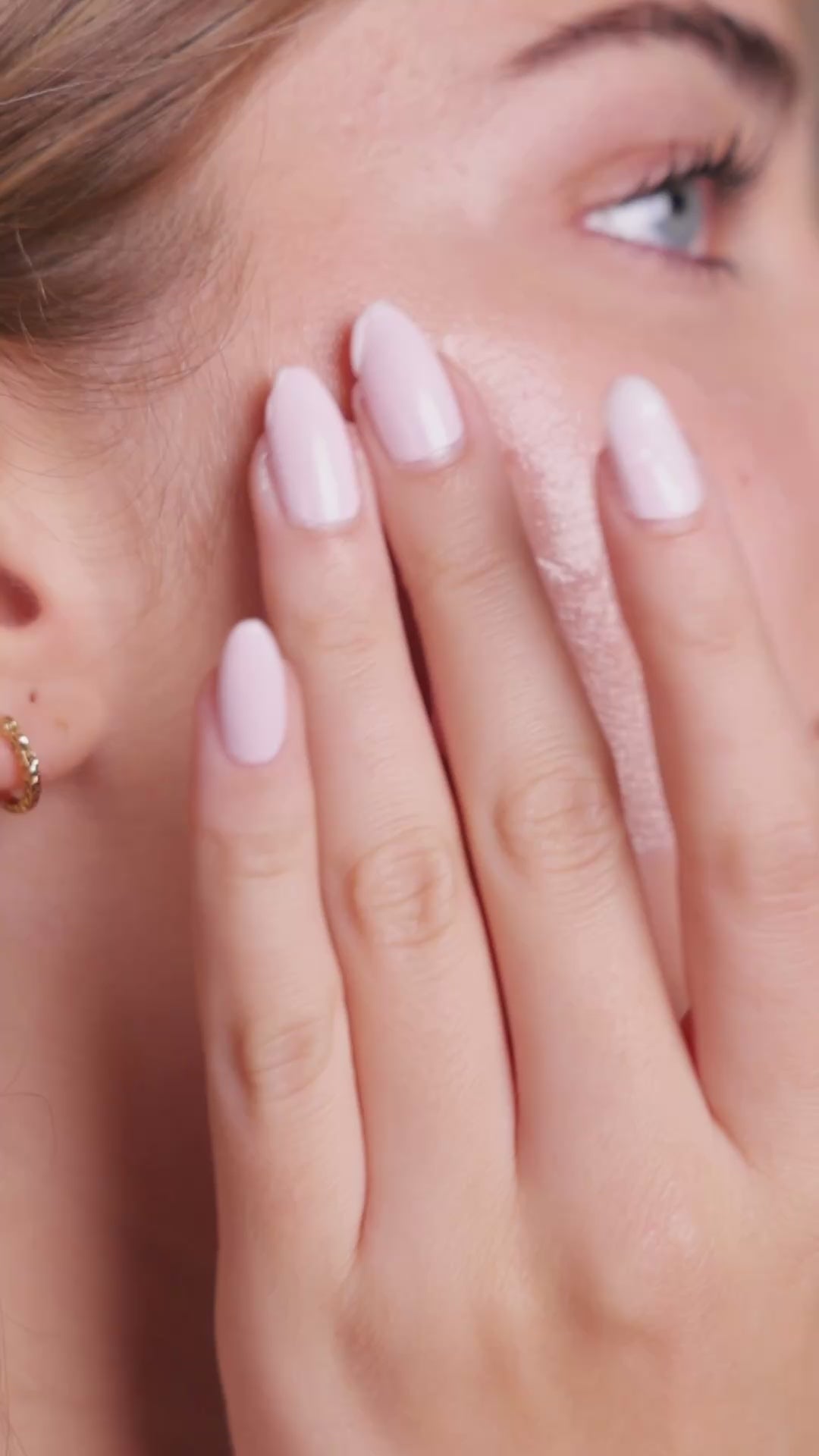 Model applying Mirror Skin Cloud Kiss moisturizer on her face.